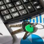 Calculator, car keys, and financial documents on a desk