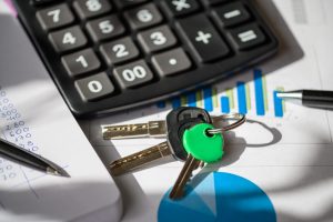 Calculator, car keys, and financial documents on a desk